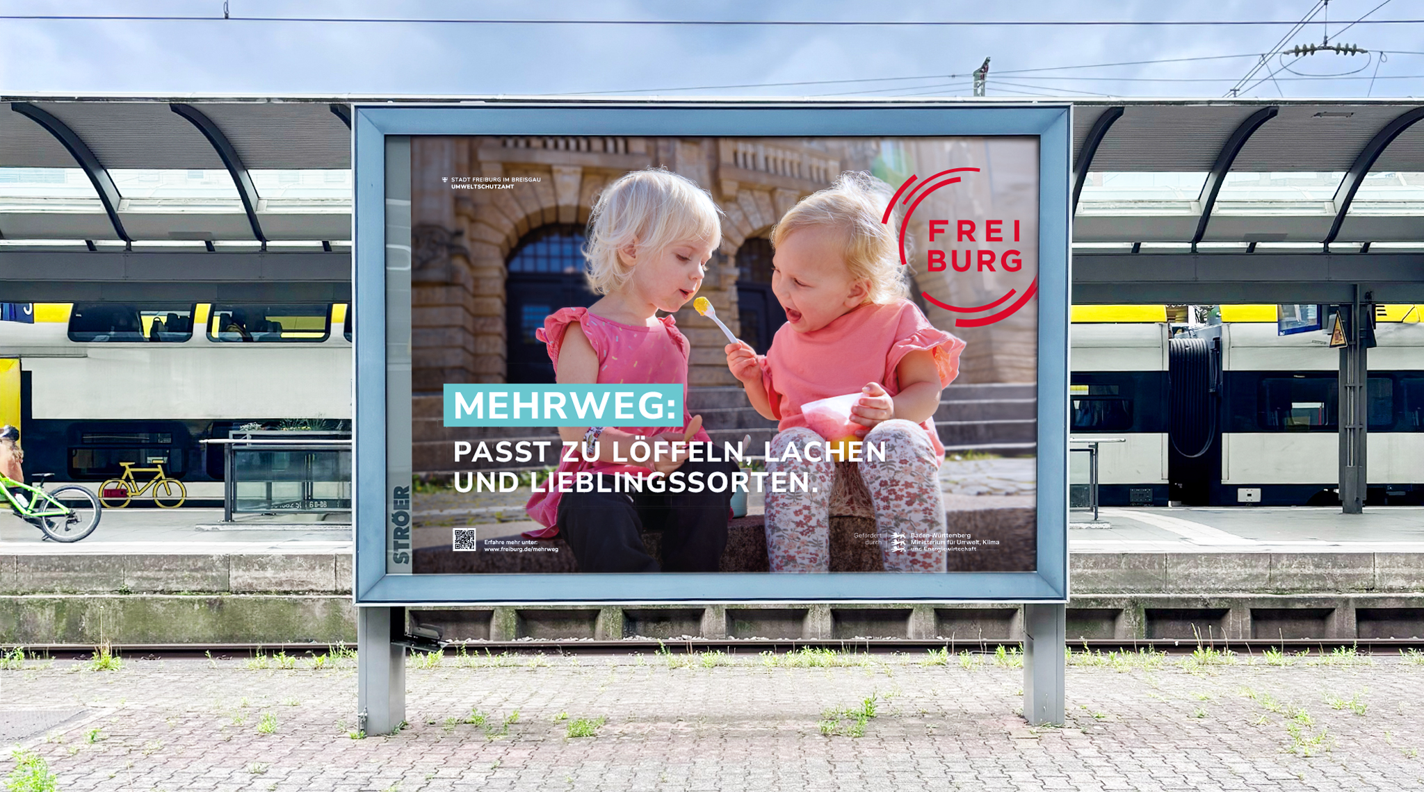 Mehrweg-Plakat am Bahnsteig: zwei Mädchen mit Eis, „Passt zu Löffeln, Lachen und Lieblingssorten.“