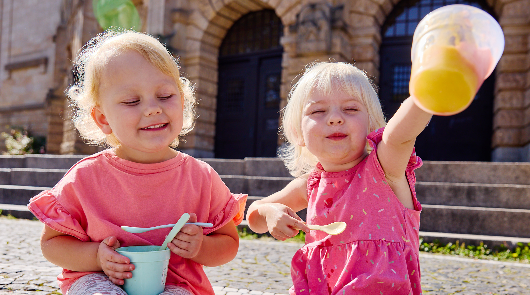 Zwei Mädchen essen Eis aus Mehrwegbechern