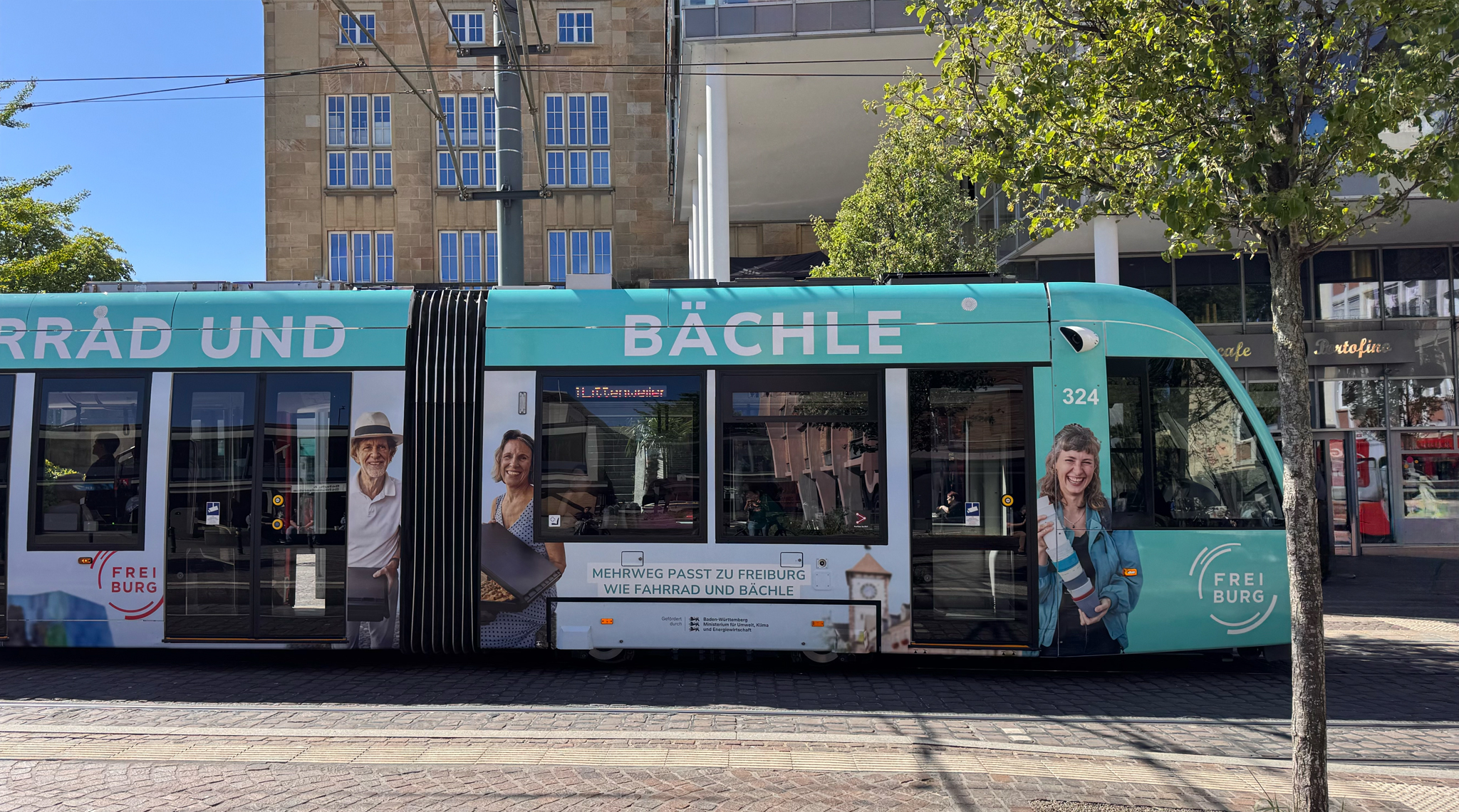 Freiburger Straßenbahn mit der Mehrweg-Werbung „Mehrweg passt zu Freiburg wie Fahrrad und Bächle“