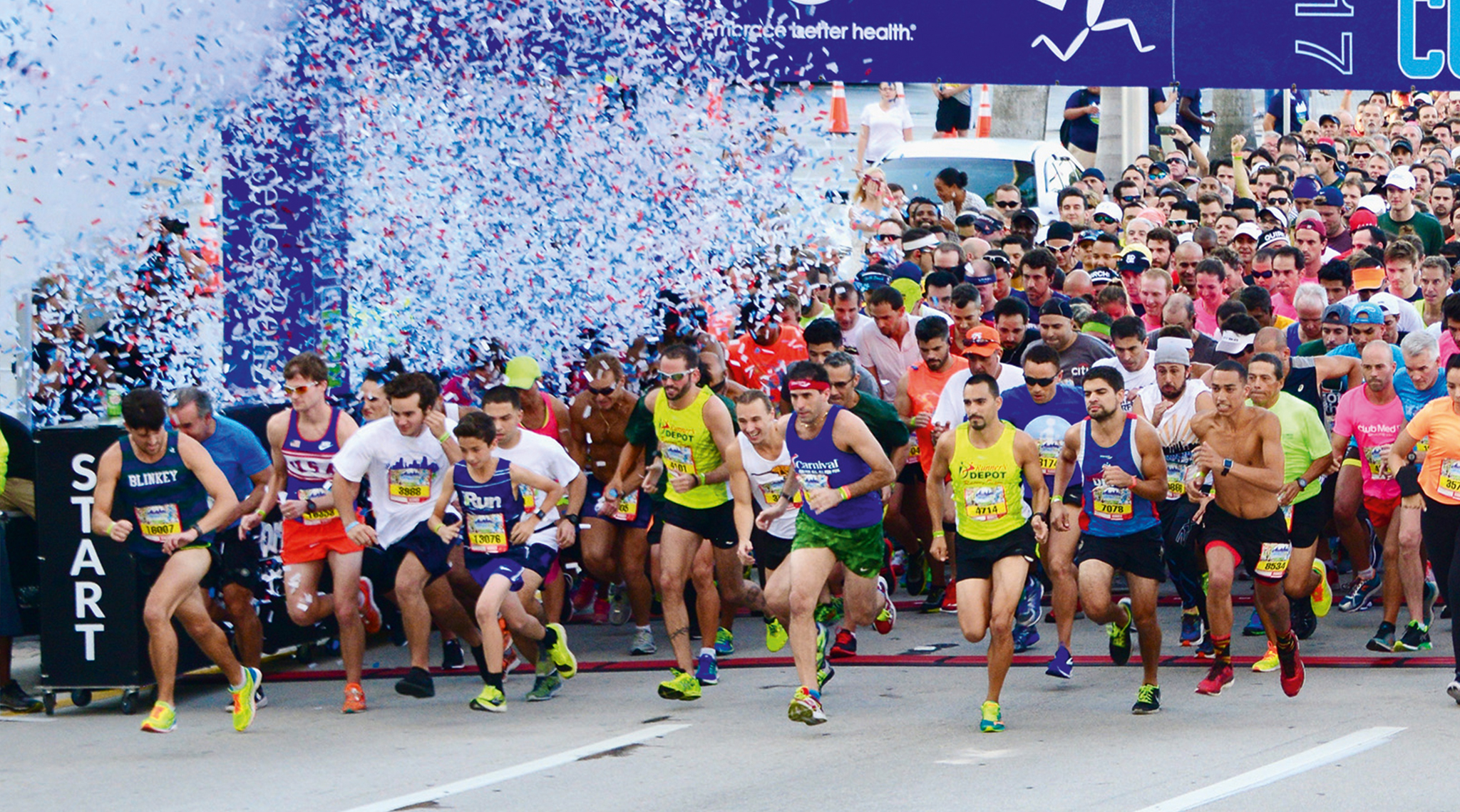Läuferinnen und Läufer beim Start eines Marathons mit Konfetti